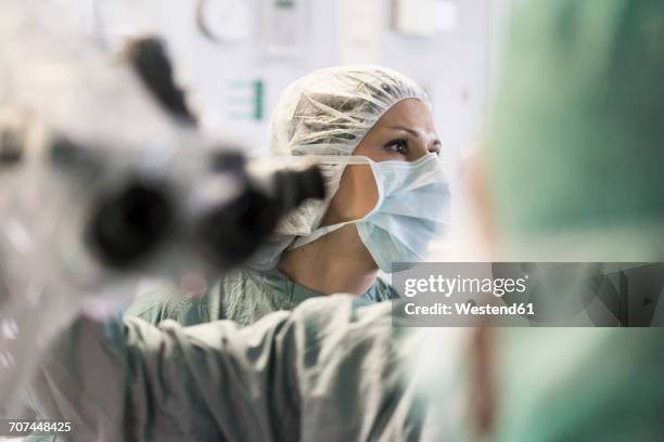 operating room nurse turning around - neurosurgery stock-fotos und bilder