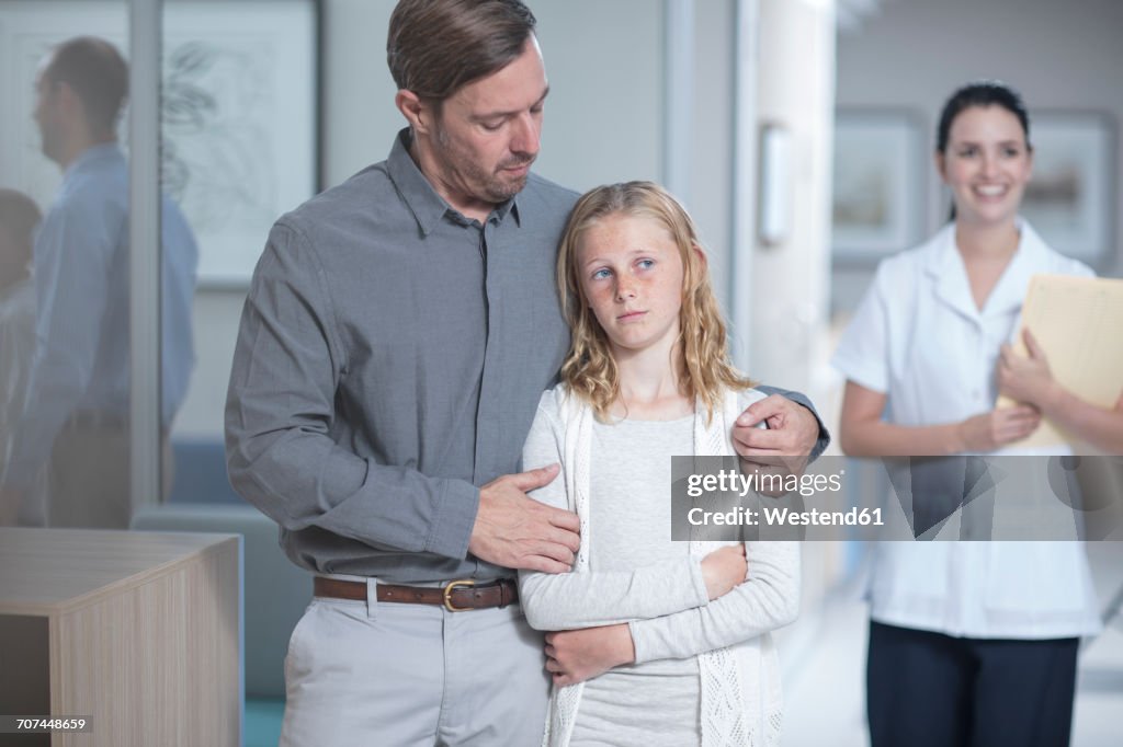 Father guiding sick daughter in hospital