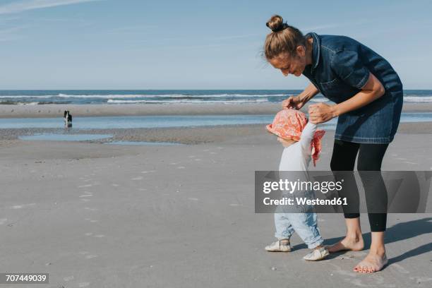 netherlands, schiermonnikoog, mother walking with little daughter on the beach - schiermonnikoog stock pictures, royalty-free photos & images