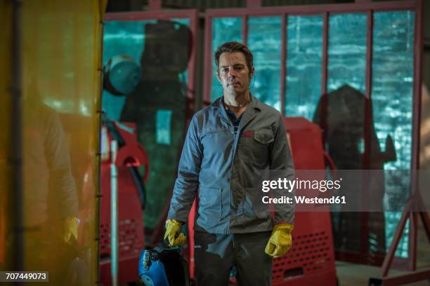 portrait of confident man holding a welding mask in a factory - steel worker stock pictures, royalty-free photos & images