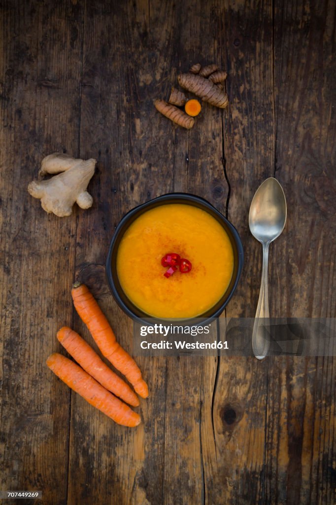 Bowl of carrot curcuma soup with ginger and chili