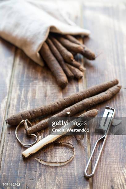 salsifies and peeler on wood - scorzonera hispanica stock pictures, royalty-free photos & images