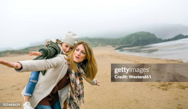 happy woman and daughter pretending to fly on the beach in winter - pretending to be a plane stock pictures, royalty-free photos & images