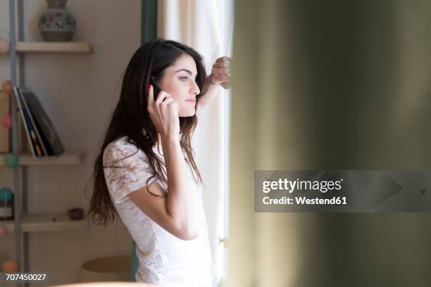 woman on the phone looking through window - 20s talking serious bildbanksfoton och bilder