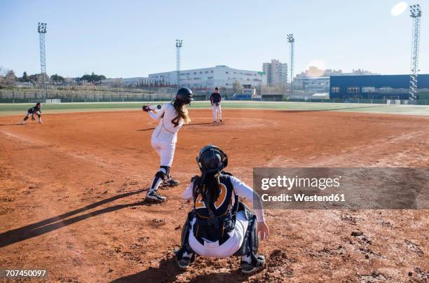 female batter hitting the ball during a baseball game - baseball pitcher catcher stock pictures, royalty-free photos & images