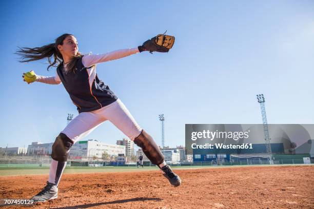female baseball player throwing the ball during a baseball game - baseball pitcher stock pictures, royalty-free photos & images