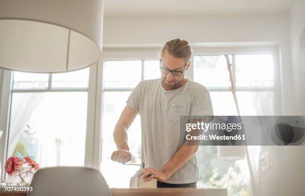 man using coffee mill on table at home - molinillo fotografías e imágenes de stock