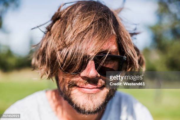 portrait of a man with unkempt hair wearing sunglasses - haare mann stock-fotos und bilder