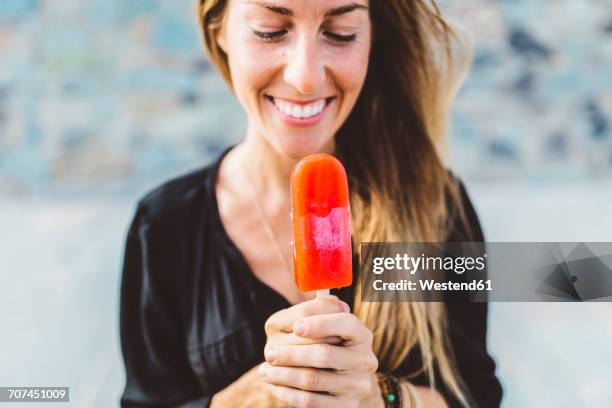 smiling young woman holding popsicle - flavored ice stock pictures, royalty-free photos & images