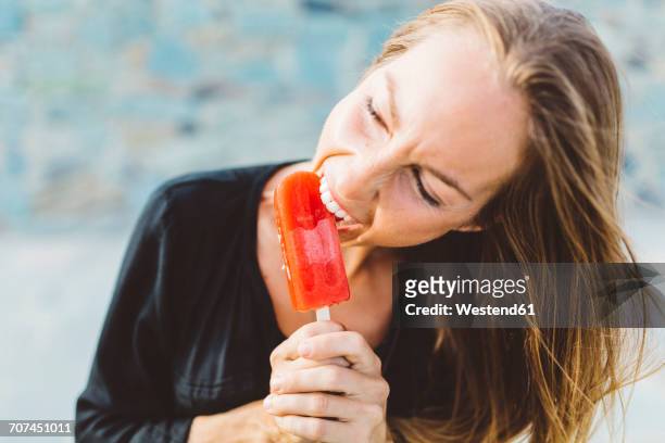 young woman biting into popsicle - ice lolly fotografías e imágenes de stock