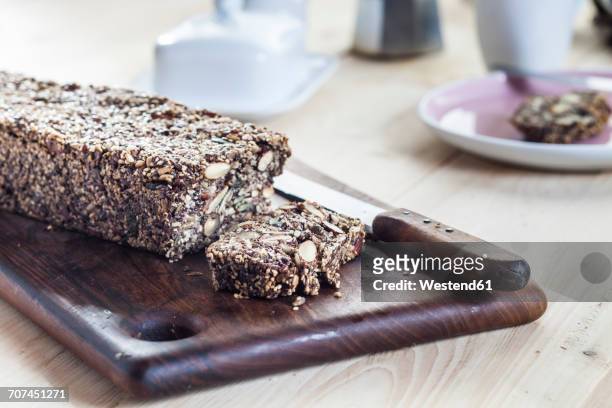 home-baked wholemeal gluten-ree bread with nuts and seeds on wooden board - paleo diet stock pictures, royalty-free photos & images