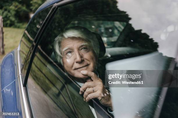 portrait of senior businessman looking through car window - passenger seat foto e immagini stock