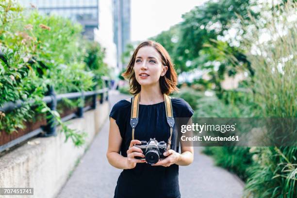 usa, new york city, woman with camera on high line park in manhattan - camera woman stock-fotos und bilder