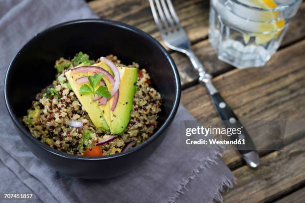 bowl of quinoa tricolore with avocado, red onion, tomatoes and flat leaf parsley - bowl of cereal stockfoto's en -beelden