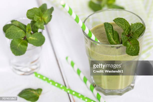 glass of green smoothie garnished with mint leaves - chlorella stock pictures, royalty-free photos & images