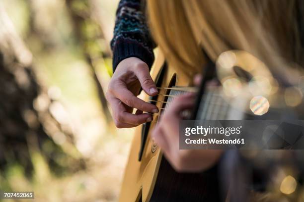 hands of woman playing guitar - liedermacher stock-fotos und bilder
