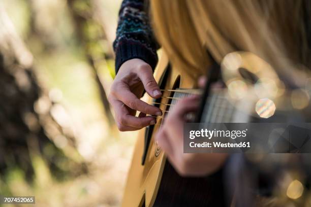 hands of woman playing guitar - zanger en componist stockfoto's en -beelden