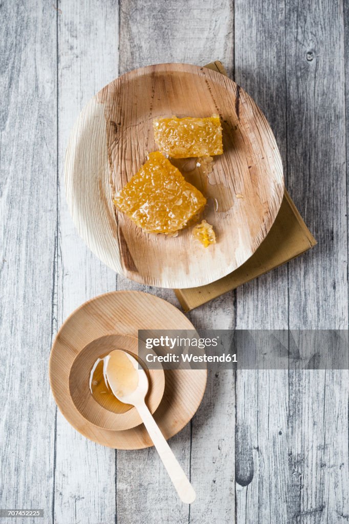 Honeycombs and honey on wooden plates