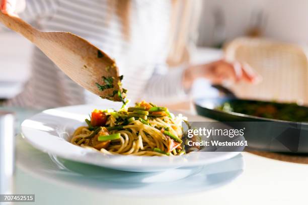 young woman serving vegan pasta dish - träsked bildbanksfoton och bilder