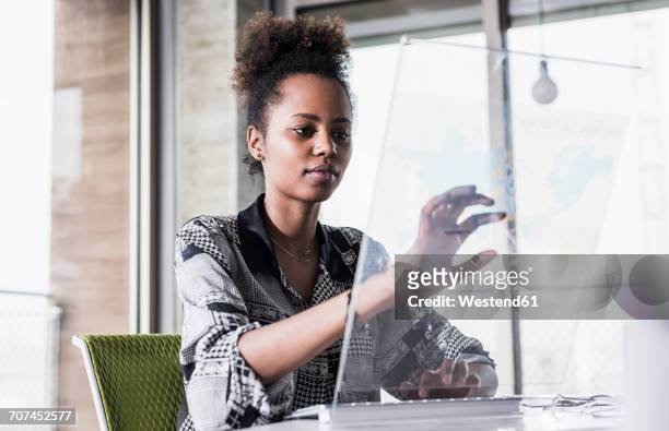 young woman working in office using transparent computer - futuristic office stock-fotos und bilder