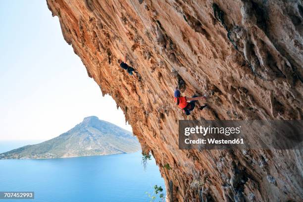 greece, kalymnos, two climbers in rock wall - free climbing stock pictures, royalty-free photos & images