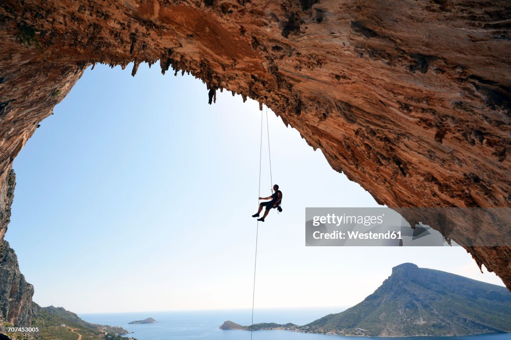Greece, Kalymnos, climber abseiling in grotto