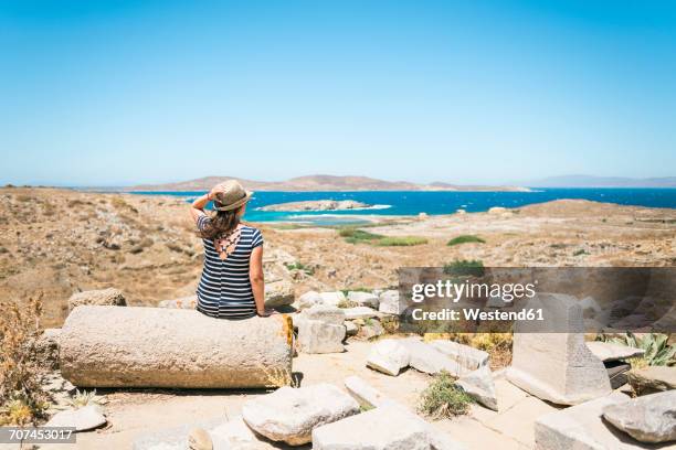 greece, mykonos, delos, tourist at archaeological site enjoying the view - delos stock-fotos und bilder