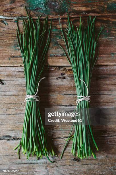 two bunches of chives on wood - cebolinho imagens e fotografias de stock