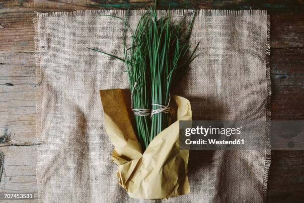 two bunches of chives wrapped in paper on cloth - cebolinho imagens e fotografias de stock