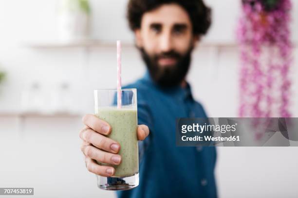 man's hand holding glass of green smoothie, close-up - smoothie close up textfreiraum stock-fotos und bilder