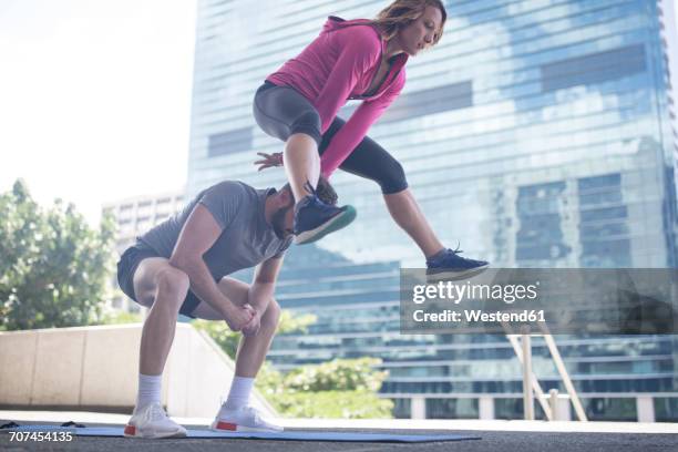 couple exercising in the city - bockspringen stock-fotos und bilder