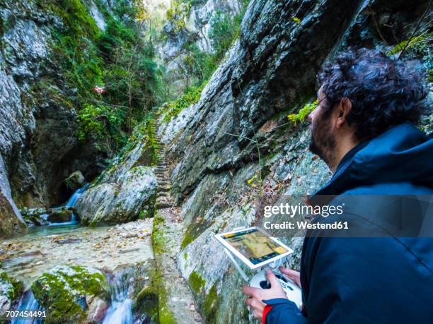 italy, umbria, monte cucco np, man flying a drone in gorge rio freddo - freddo stock pictures, royalty-free photos & images