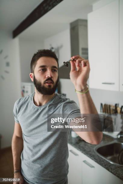 young man playing darts in his kitchen - throwing darts stock pictures, royalty-free photos & images