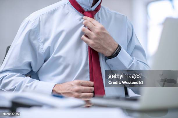 person in office fixing his red tie - interview preparation stock pictures, royalty-free photos & images