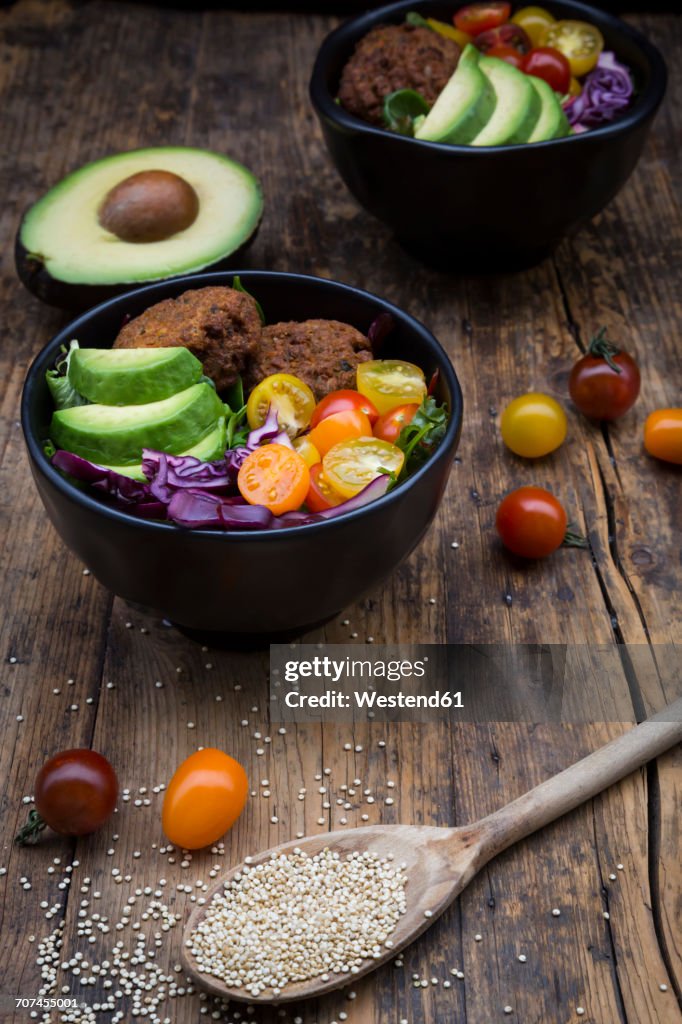 Lunch bowls of leaf salad, red cabbage, avocado, tomatoes and quinoa fritters