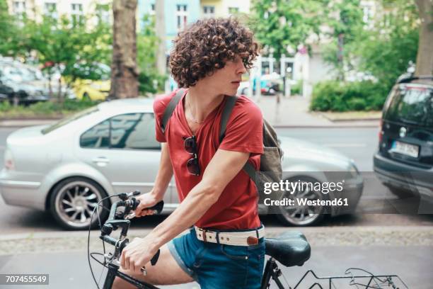 young man riding bicycle on pavement turning around - car turning stock pictures, royalty-free photos & images