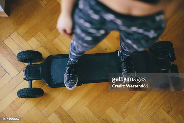 young woman standing on electric skateboard - electric skateboard stock pictures, royalty-free photos & images