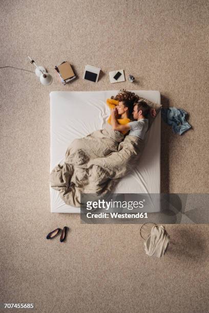couple lying in bed, top view - man and woman cuddling in bed stock-fotos und bilder