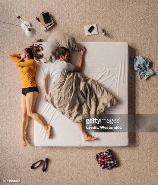 man lying in bed with woman lying besides, top view - unbequemlichkeit stock-fotos und bilder