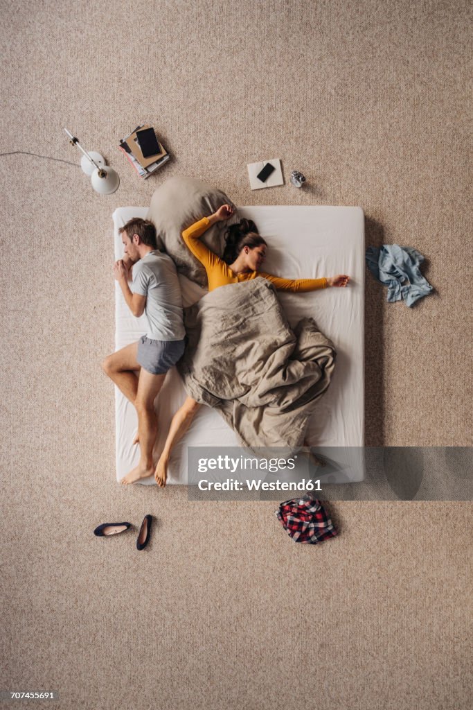 Couple lying in bed, top view