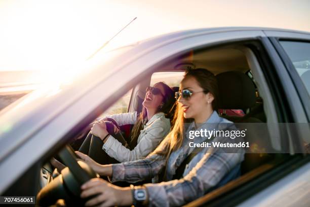 two young women traveling in a car - woman in car stock pictures, royalty-free photos & images