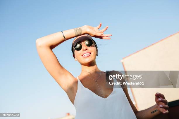 young woman with sunglasses shielding eyes against sun - shielding eyes stock pictures, royalty-free photos & images