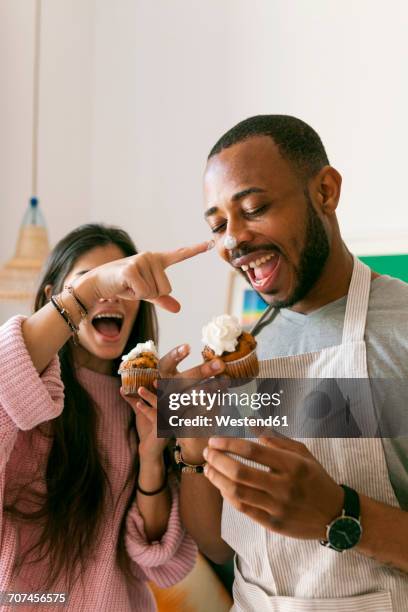 young couple having fun, eating fresh cupcakes - whipped stock-fotos und bilder