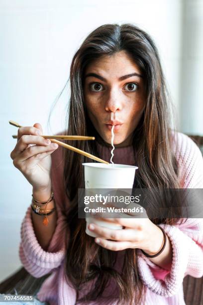 young woman eating chinese noodles - begehren stock-fotos und bilder