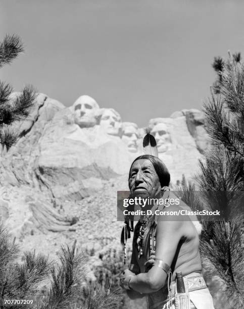 1960s PORTRAIT OF AMERICAN INDIAN IN FRONT OF MOUNT RUSHMORE