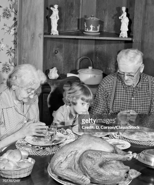 1950s FAMILY THANKSGIVING DINNER PRAYING GIRL AND GRANDPARENTS