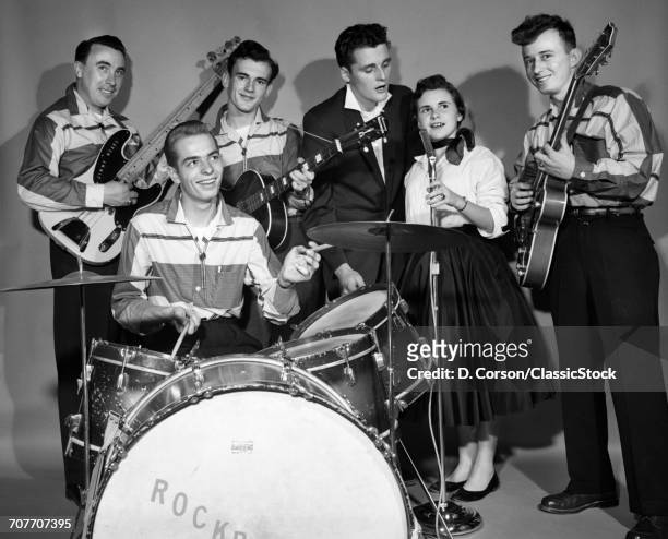 1950s SMILING TEENAGE SIX MEMBER ROCK-A-BILLY BAND IN MATCHING OUTFITS LOOKING AT CAMERA