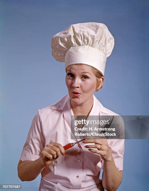 1960s WOMAN COOK WEARING WHITE CHEF TOQUE HOLD SPOON SURPRISED EXPRESSION LOOKING AT CAMERA