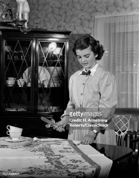 1940s 1950s TEEN GIRL SETTING THE TABLE IN DINING ROOM