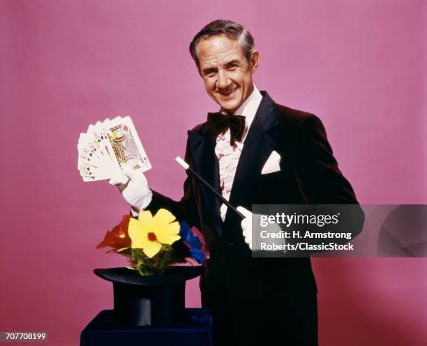 1970s MAGICIAN PERFORMING MAGIC CARD TRICK WEARING TUXEDO AND WHITE GLOVES